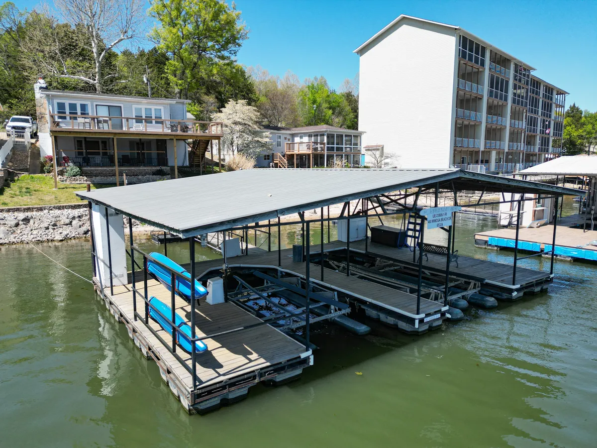 The hero image showcases an inviting lakeside dock with comfortable seating overlooking a tranquil, expansive cove. The calm water glimmers under the soft hues of sunset, framed by lush trees and distant lakefront homes, setting the scene for relaxation, water sports, fishing, or gathering with loved ones right at the water's edge.