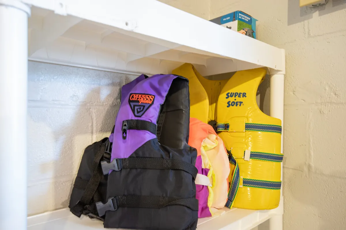 An interior storage area with colorful life jackets neatly organized on shelves, underscoring safety and preparation for water-based adventures. The vibrant jackets evoke memories of fun and active days on the lake.
